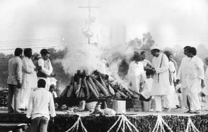 Indira Gandhi's family watches the pyre of the late Prime Minister during the cremation ceremony on November 3, 1984.