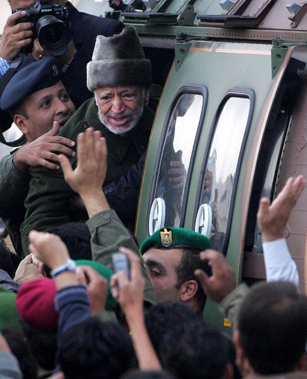 Ailing Palestinian leader Yasser Arafat says goodbye to well-wishers as he boards a Jordanian army helicopter at dawn at the  Muqatta, his West Bank offices in Ramallah 29 October 2004, en route for Amman, from where he went to Paris to seek medical treatment.