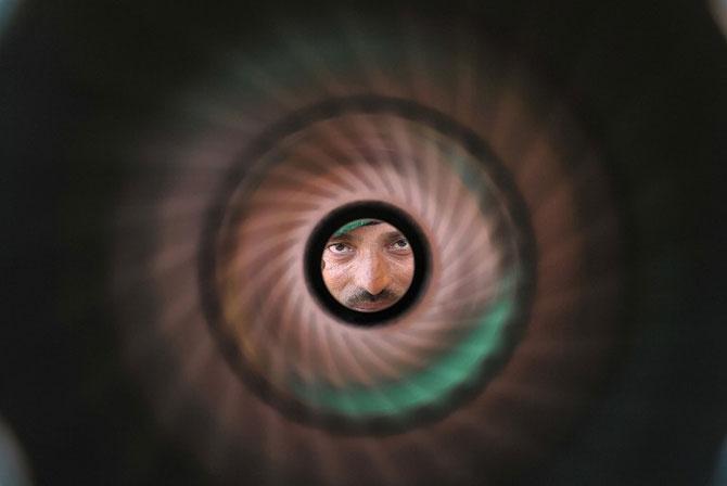 An Indian Army personnel looks through the barrel of a rocket launcher at the display of arms and equipment at the Bison Polo Ground in Secunderabad, the twin city of Hyderabad. Pic/AFP