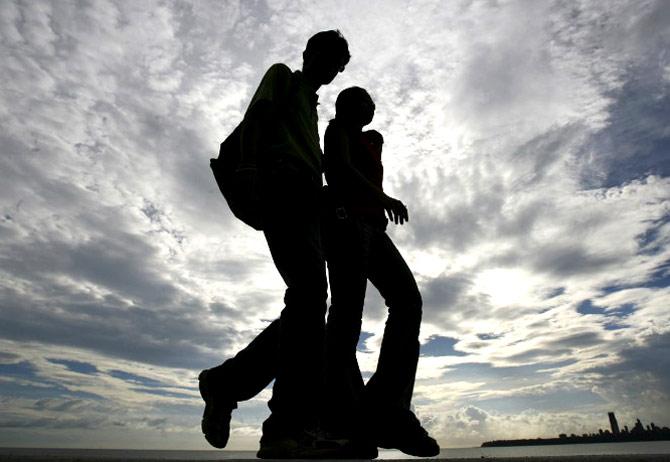 A couple enjoys the rays of light as clouds hover over the Arabian Sea in Mumbai, on June 2, 2007