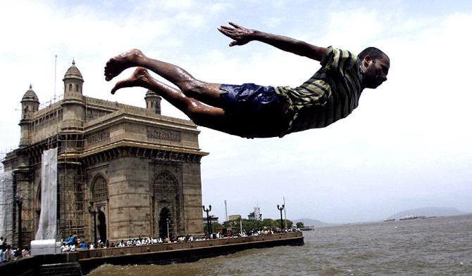 A man leaps into the waters of the Arabian Sea near the Gateway of India in Mumbai on July 5, 2008