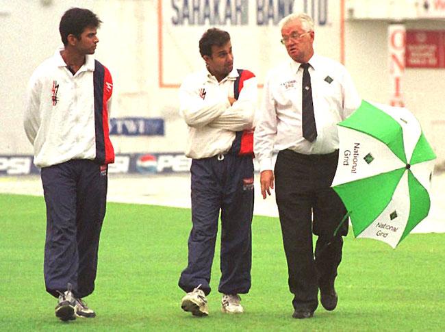 Howzzat? Rahul Dravid (L) and Nayan Mongia (C) listen very attentively to advice being given by umpire Cyril Mitchley as they stroll on the field at Vidarbha Cricket Association stadium, Nagpur during a rain interruption in Test between India and Sri Lanka in the late 90s
