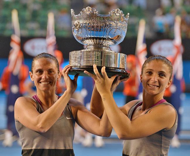 Italy's Roberta Vinci (L) and Sara Errani (R) pose with the trophy and ballboys as they celebrate after winning their women's doubles final against Russia's Elena Vesnina and Ekaterina Makarova