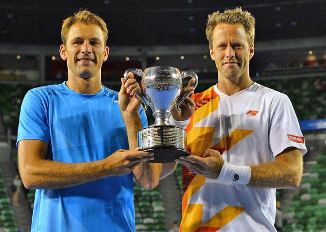 Poland's Lukasz Kubot (L) and Sweden's Robert Lindstedt (R) celebrate with the trophy after their victory against Eric Butorac of the US and South Africa's Raven Klaasen during the men's doubles final