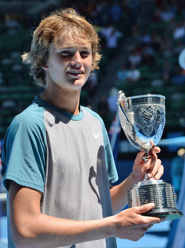 Alexander Zverev of Germany poses with the trophy as he celebrates after victory in his boy's singles final match against Stefan Kozlov of the US