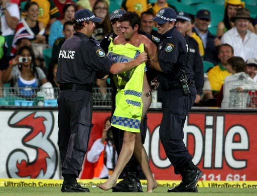 Cover-up! A streaker (C) is taken away by police during the one-day match between Australia and Sri Lanka in Sydney on February 8, 2008. Pic/ AFP