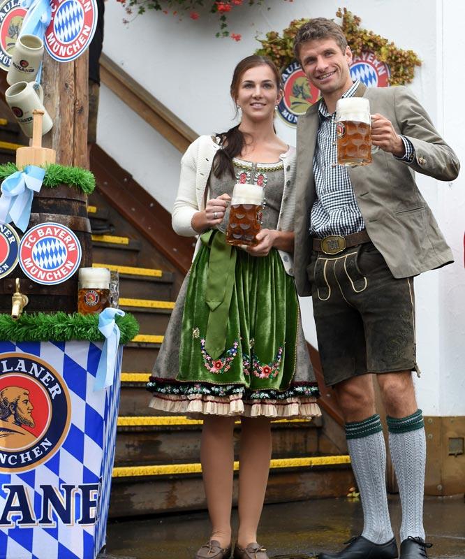 Bayern Munich's striker Thomas Mueller (R) and his wife Lisa Mueller (L) pose during the traditional visit of FC Bayern Munich at the beer festival.