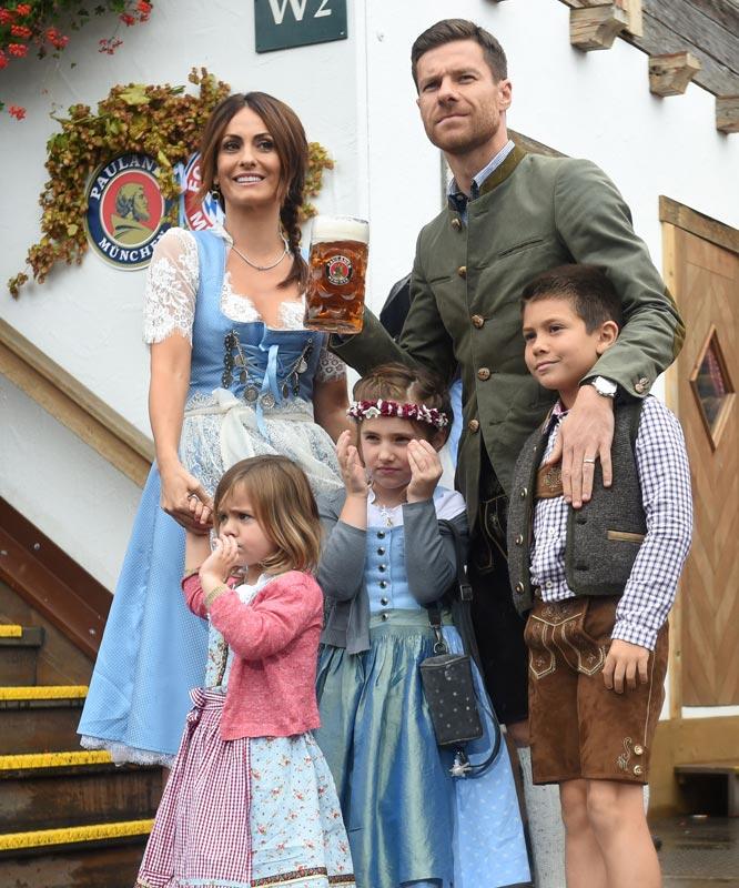 Bayern Munich's Spanish defender Xavi Alonso (R) and his wife Nagore Aramburu (L) pose with children.