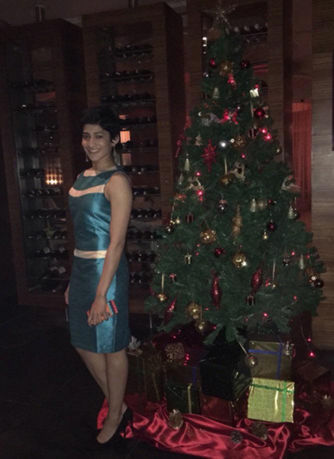 Ashwini looks sexy in a short green dress posing near a Christmas tree