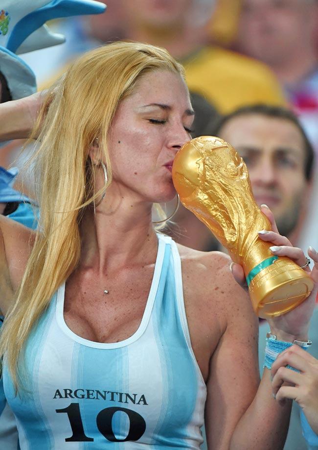 Argentina's fan kisses a fake trophy before for the Group F football match between Argentina and Bosnia-Hercegovina
