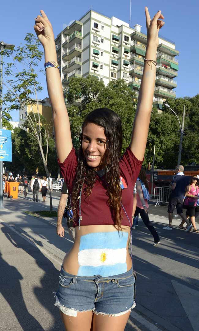 An Argentinian fan poses covered on body paint in the colours of the Argentinian national flag
