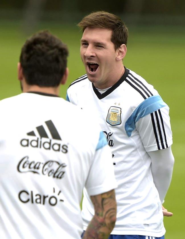 Lionel Messi (R) yawns next to teammate forward Ezequiel Lavezzi at the beginning of a training session