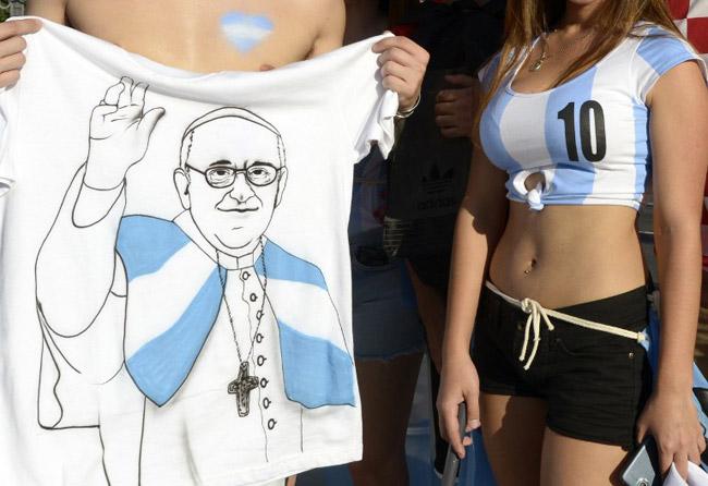 Argentinian supporters pose with a t-shirt featuring a picture of Pope Francis outside of the Maracana Stadium