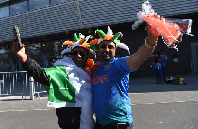 Two India fans pose for the camera ahead of the ICC Champions trophy cricket match between India and Pakistan