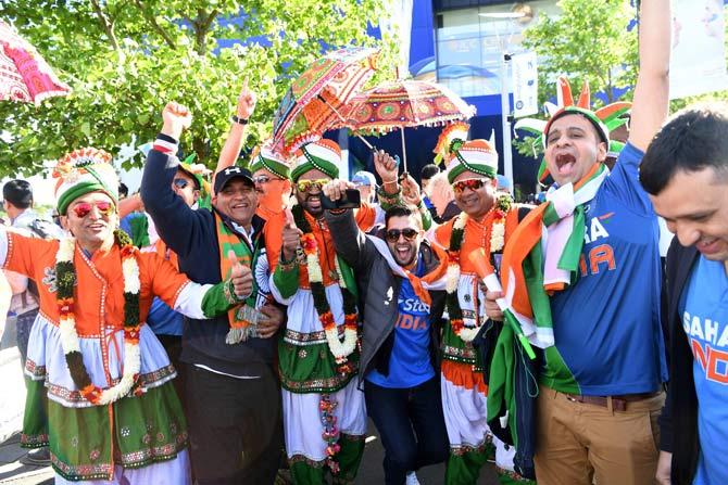 India fans dance ahead of the ICC Champions trophy cricket match between India and Pakistan