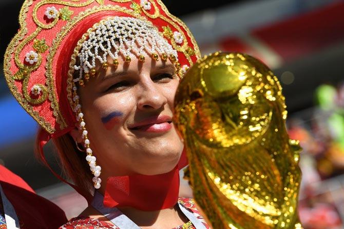 A Russia's fan poses with a replica of the FIFA Russia 2018 World Cup trophy before the Russia 2018 World Cup round of 16 football match between Spain and Russia at the Luzhniki Stadium in Moscow on July 1, 2018.