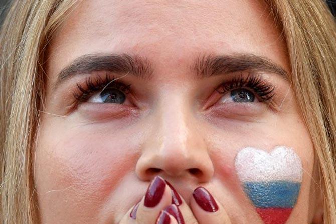 A Russia supporter reacts as she watches the Russia 2018 World Cup Group A football match between Uruguay and Russia on a giant screen at the Fifa Fans Fest in Saint Petersburg on June 25, 2018.