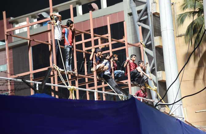 Cricket fans watching Mumbai Indians vs Royal Challengers Bangalore match played at the Wankhede stadium from the scaffolding built at the neighbouring BHA stadium in Mumbai. Pic/Suresh Karkera