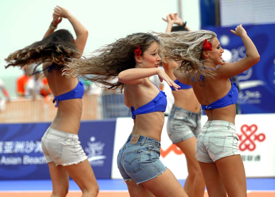 Cheerleaders throw their hands up in the air...