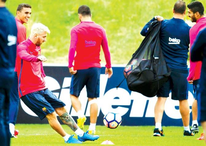Barcelona's Uruguayan forward Luis Suarez (R) and Barcelona's Argentinian forward Lionel Messi (2L) take part in a team training session at St George's Park near Burton-on-Trent, central England