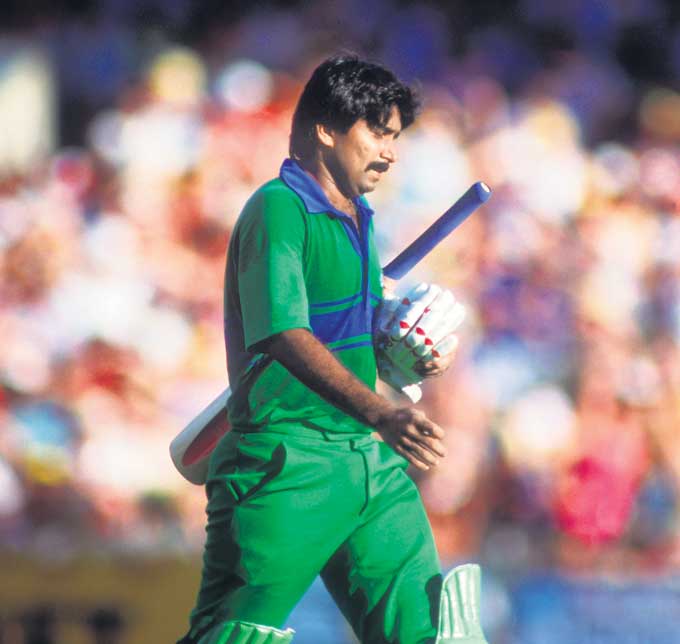 Javed Miandad walks back after being dismissed