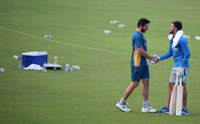 Virat Kohli and Shahid Afridi shake hands at a training session during 2016 World T20 (Pic/ AFP)