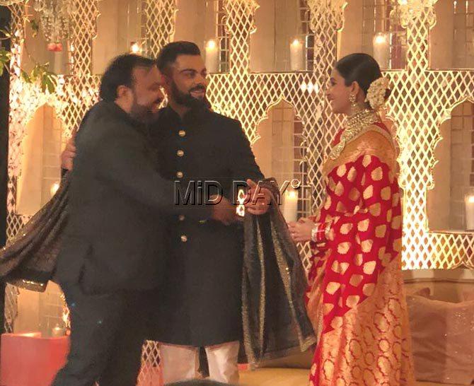 A guest greets Virat Kohli and Anushka Sharma
