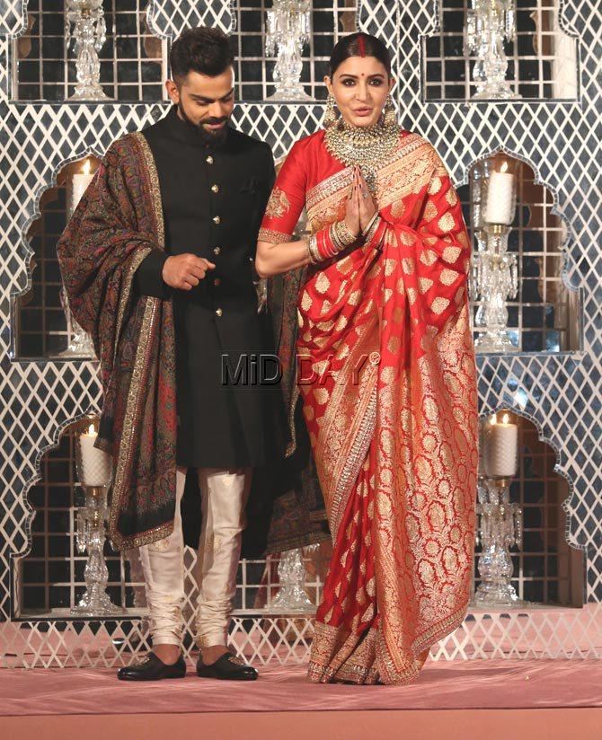 While Anushka Sharma greets guests with 'namaste', we wonder what has got Virat Kohli's attention?