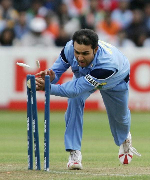 Virender Sehwag of India knocks the bails off in an attempt to run-out Pakistan's Yousuf Youhana