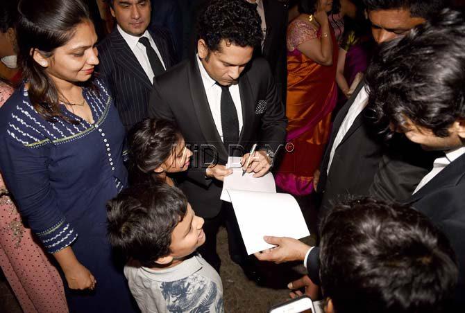 Sachin Tendulkarsigns autographs for his fans