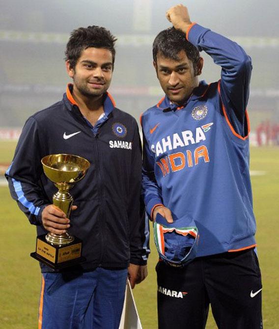 Virat Kohli (L) holds the man of the match trophy as captain Mahendra Singh Dhoni looks on after the Tri-Nations tournament one day international cricket match at The Sher-e Bangla National Stadium in Dhaka on January 11, 2010. India beat Bangladesh by six wickets. Pic/AFP