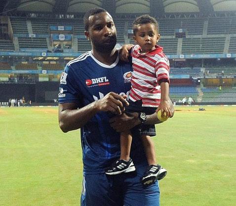 Mumbai Indians and West Indies batsman Kieron Pollard carries his son Kaiden as he arrives for a press conference after an IPL Twenty20 cricket match in April 11, 2012. Pic/ AFP