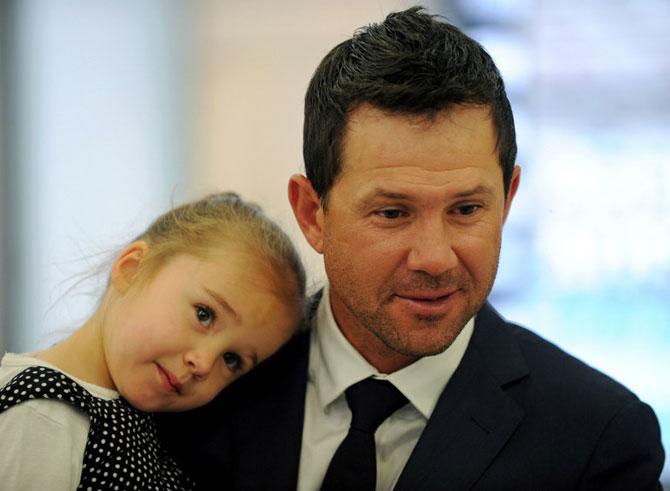 Former Australian cricketer Ricky Ponting holds his daughter Emmy at Sydney International Airport, after arriving back from South Africa in November 2011. Pic/ AFP