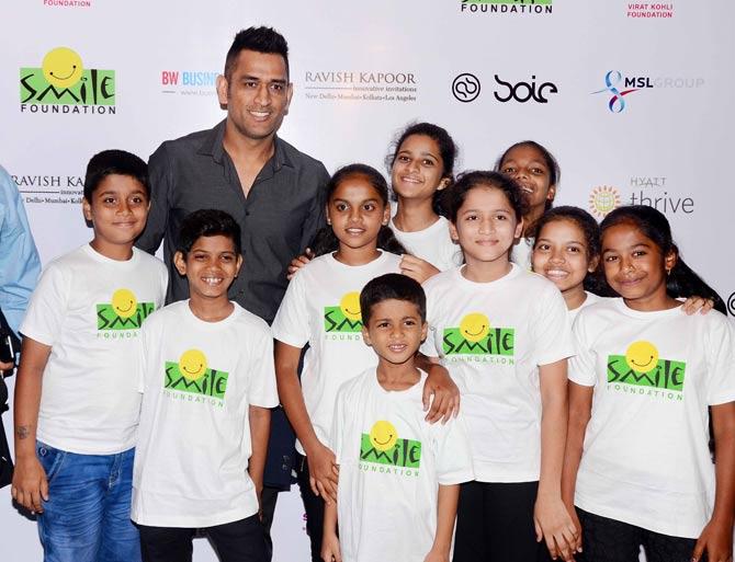 MS Dhoni poses with the children