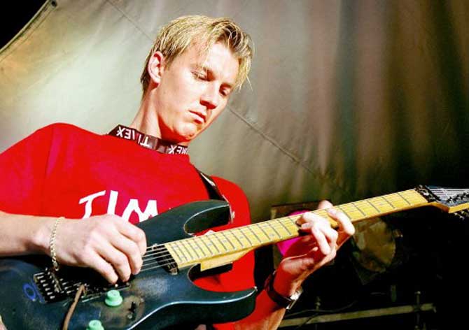 Australian cricketer, Brett Lee plays the guitar along with the Indian band Aqua Flow (not in picture) during a special show 'Rock with Brett' in Bombay in October 2004.