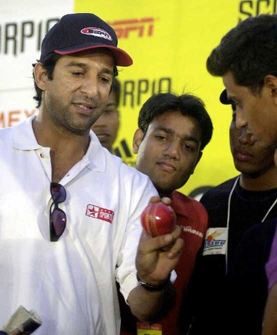 Former Pakistani cricketer and sports comentator Wasim Akram (L) give tips to aspiring Indian cricketers at the 'Speedester' hunt for fast bowlers at Shivaji Park in Bombay in November 2003.