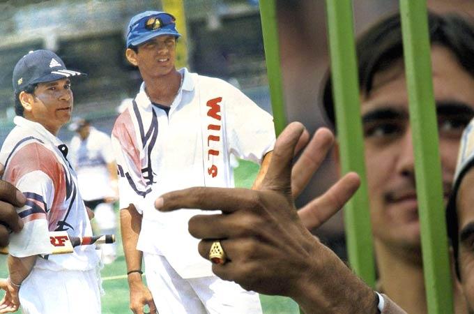 Wall in one: A Pakistani cricket fan holds a placard displaying pictures of Rahul Dravid and Sachin Tendulkar (R) during an ODI in Peshawar. Pic/ AFP