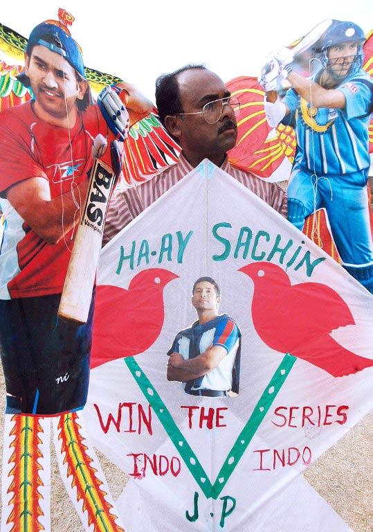 High-flying tribute: A cricket-crazy fan holds specially-designed Chinese kites carrying pictures of Mahendra Singh Dhoni (L), Yuvraj Singh (R) and Sachin Tendulkar (bottom), in Amritsar, in Punjab. Pic/ AFP