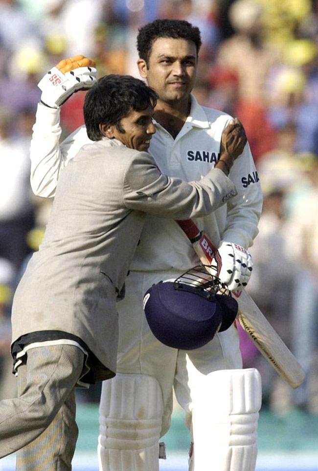 Virender Sehwag being congratulated by an unidentified fan as he celebrates scoring a century on the third day of the second Test match between India and New Zealand at Mohali, October 18, 2003.