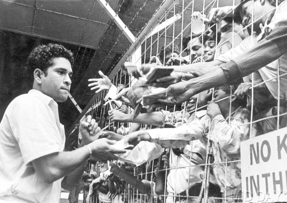 Sachin Tendulkar signing autographs for many of his fans